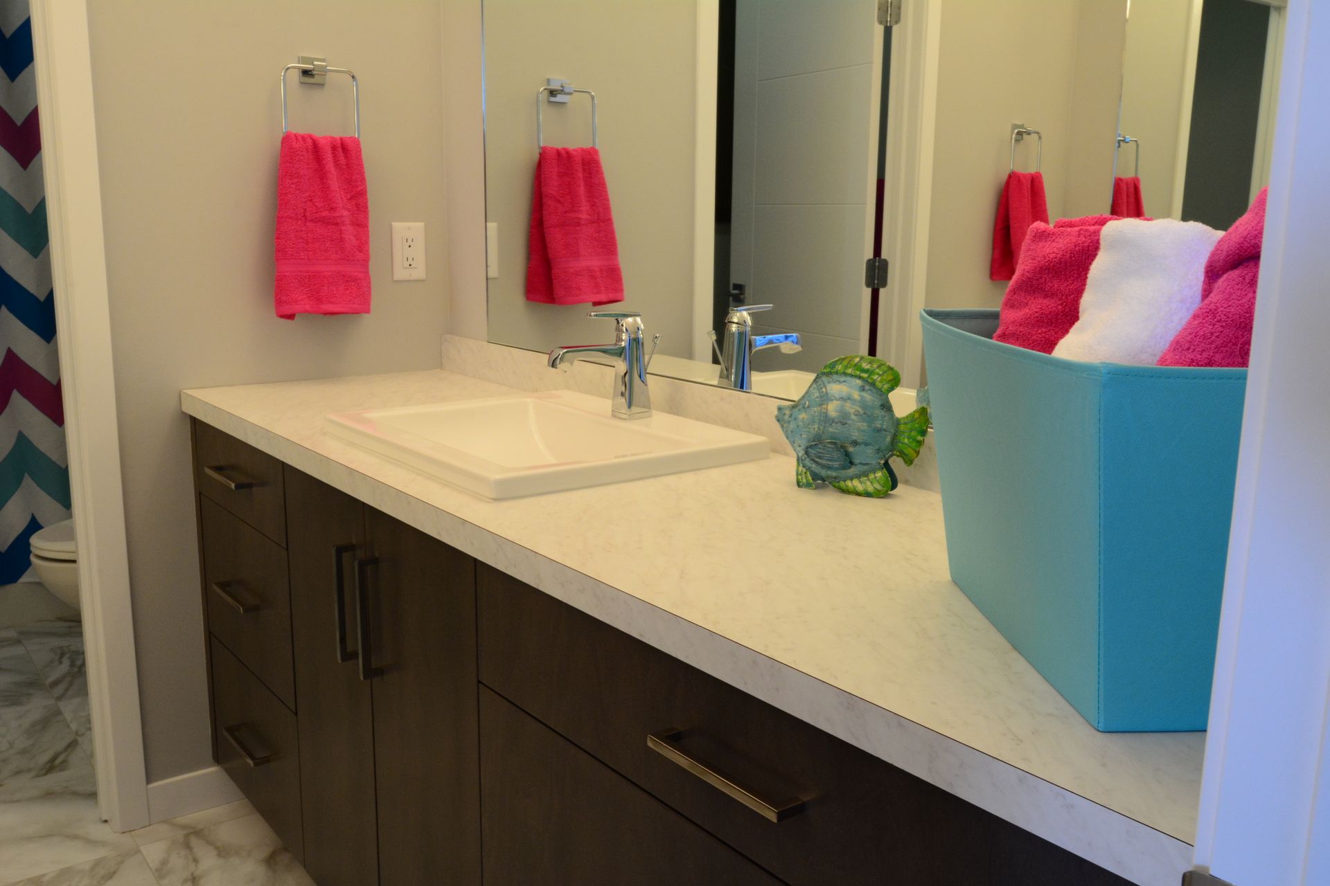 A bathroom with two sinks and a blue box of towels