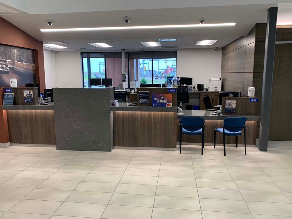 The inside of a bank with a counter and chairs.