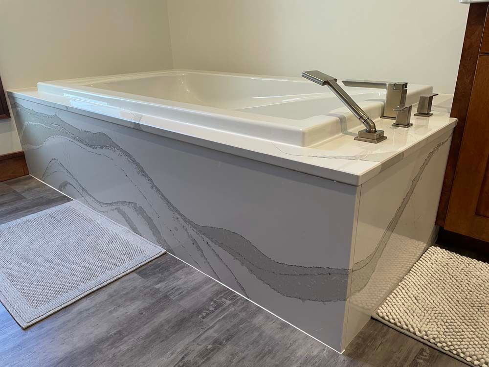 A bathtub is sitting on top of a wooden floor in a bathroom.