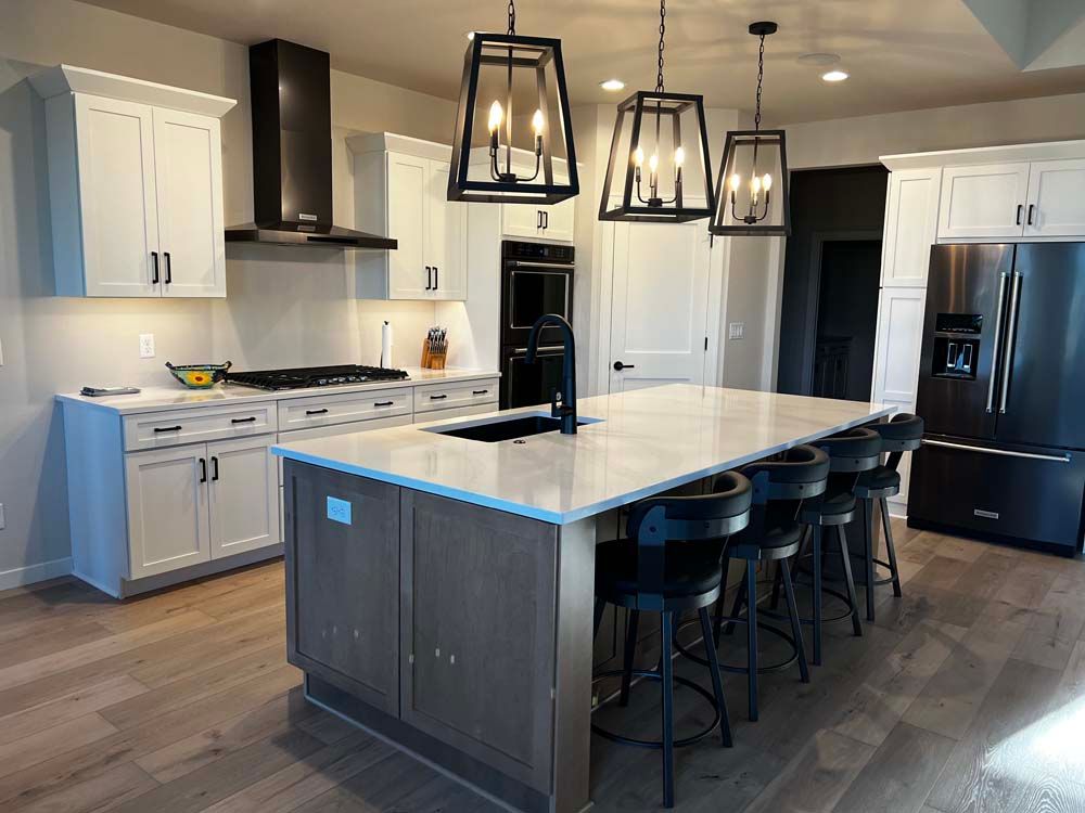 A kitchen with white cabinets , stainless steel appliances , and a large island.