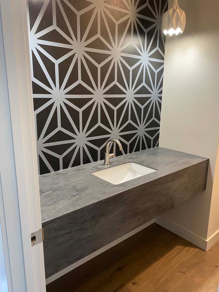 A bathroom with a sink and a black and white wall.