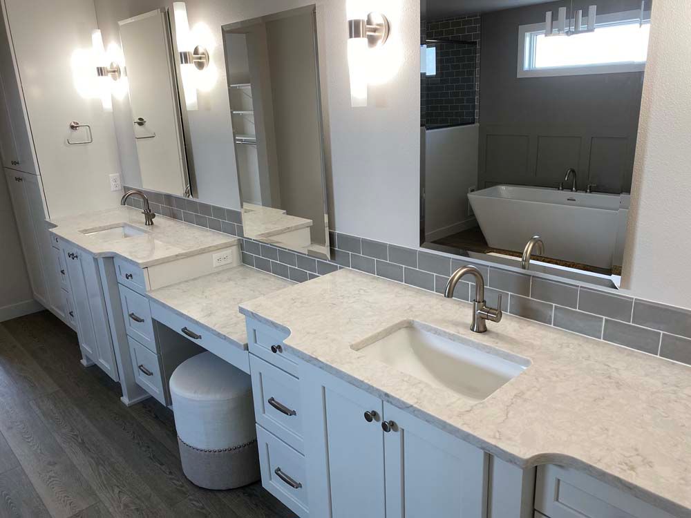 A bathroom with two sinks , two mirrors and a bathtub.