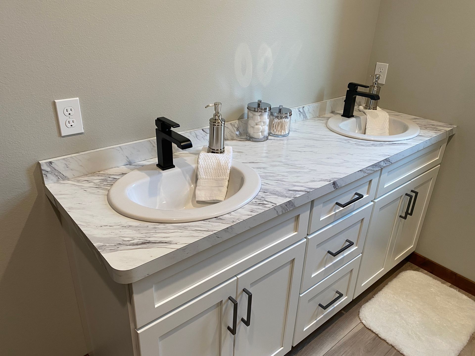 A bathroom with two sinks and a rug on the floor.