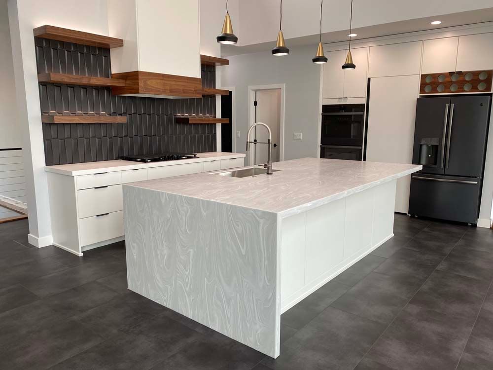 A kitchen with a large island and a refrigerator.