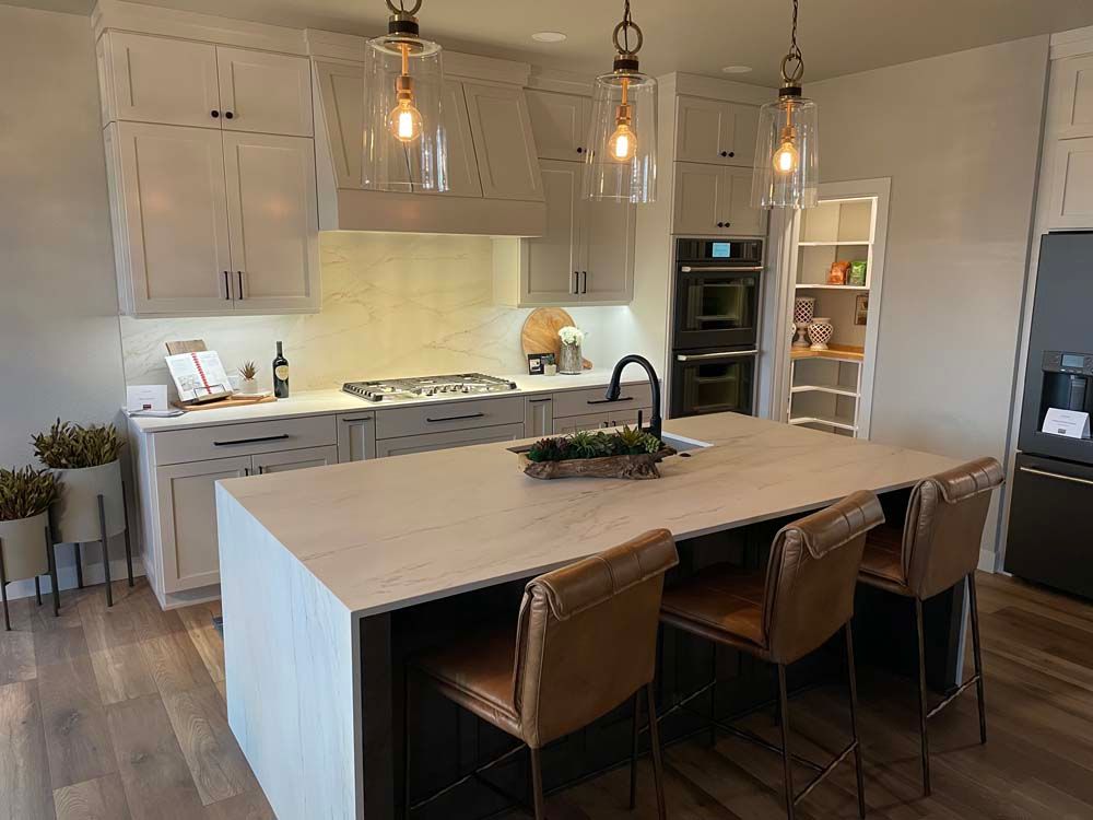 A kitchen with a large island and chairs in it.