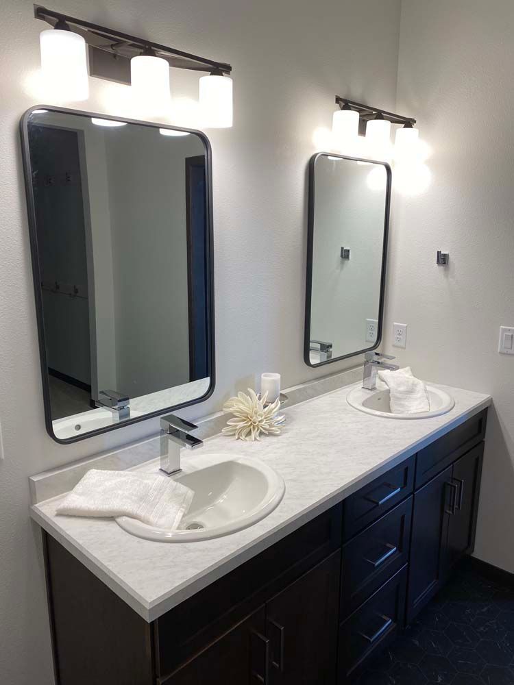 A bathroom with two sinks and two mirrors.