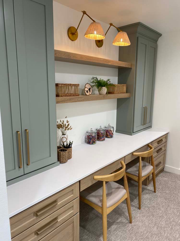A room with a desk , chairs , shelves and cabinets.