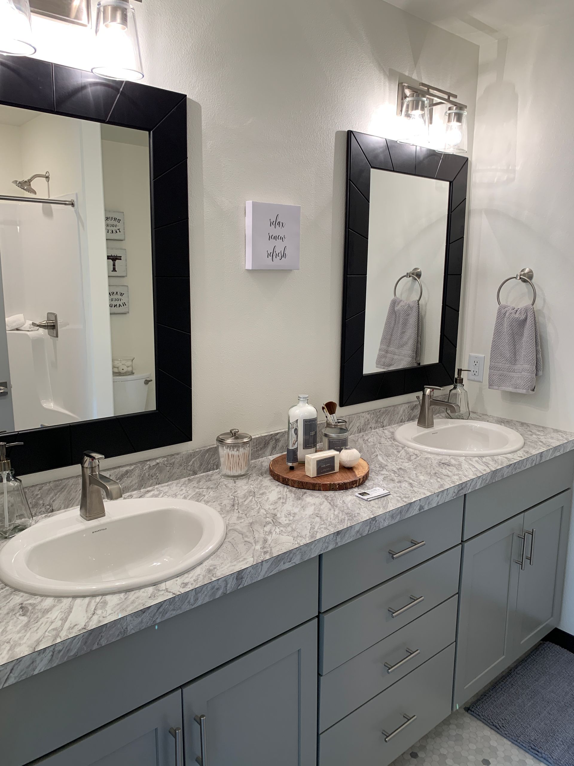 A bathroom with two sinks and two mirrors.
