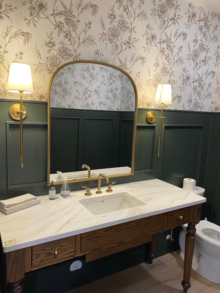 A bathroom with a sink , mirror and toilet.