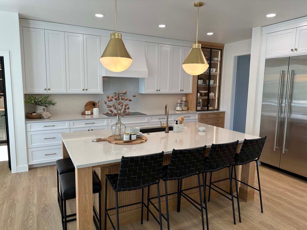 A kitchen with white cabinets , stainless steel appliances , and a large island.