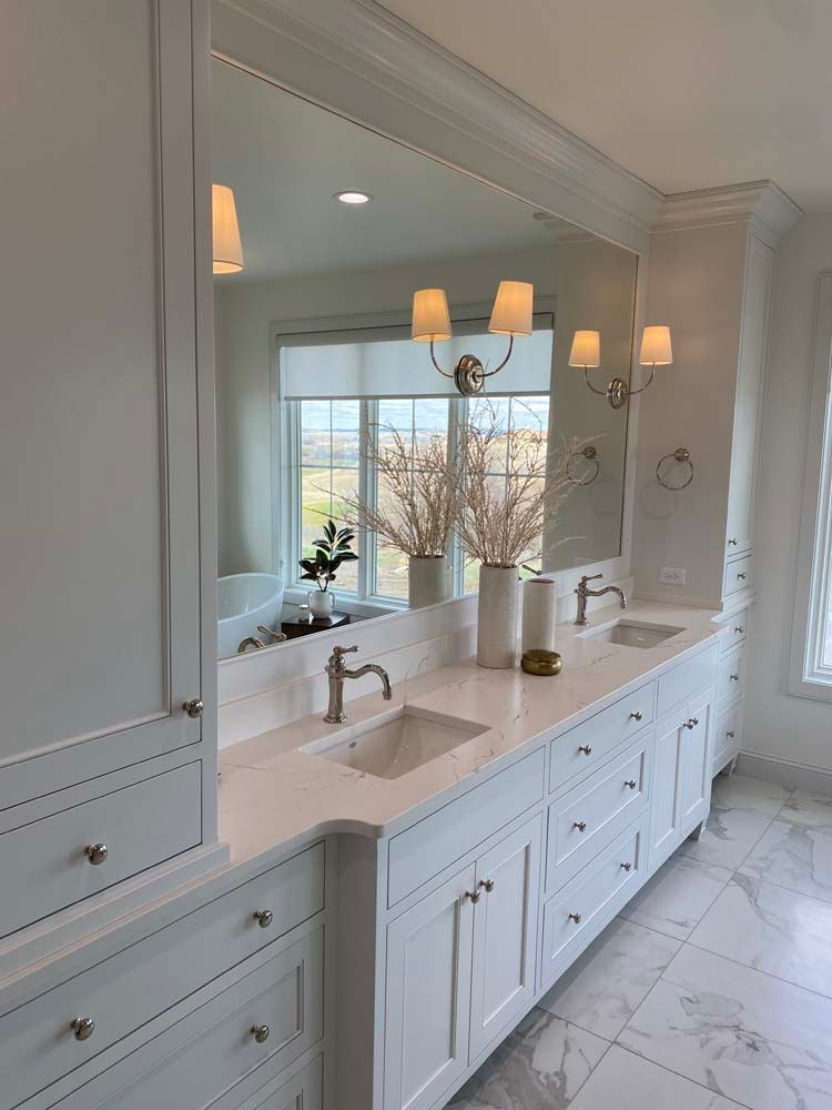 A bathroom with two sinks and a large mirror.