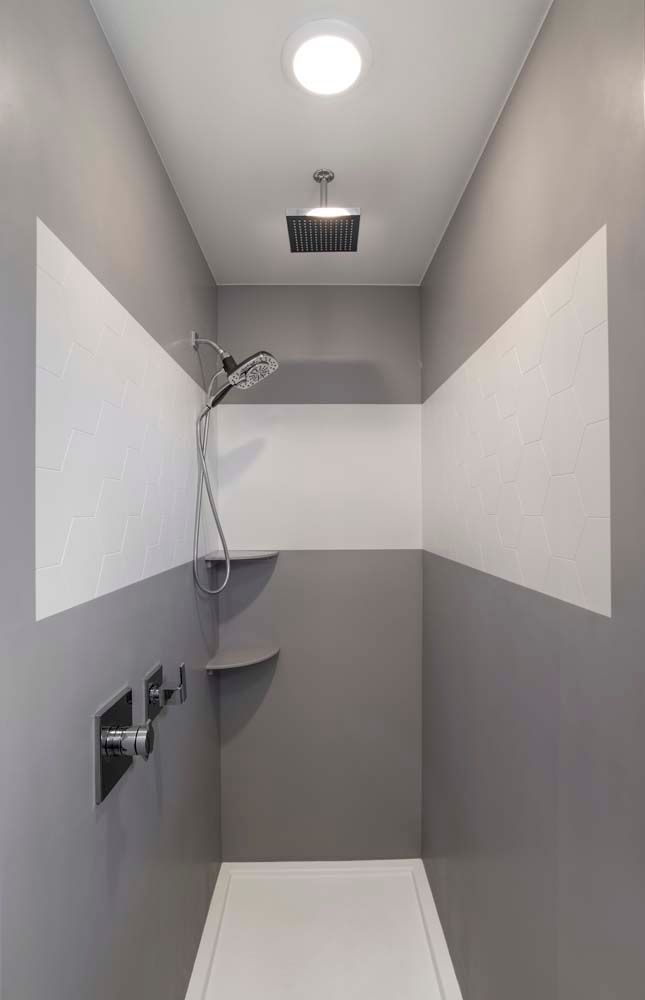 A bathroom with a shower and a ceiling light.