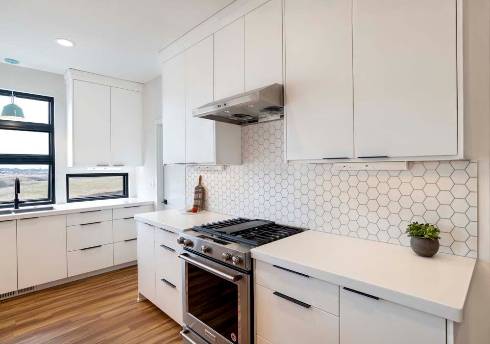 A kitchen with white cabinets and stainless steel appliances.
