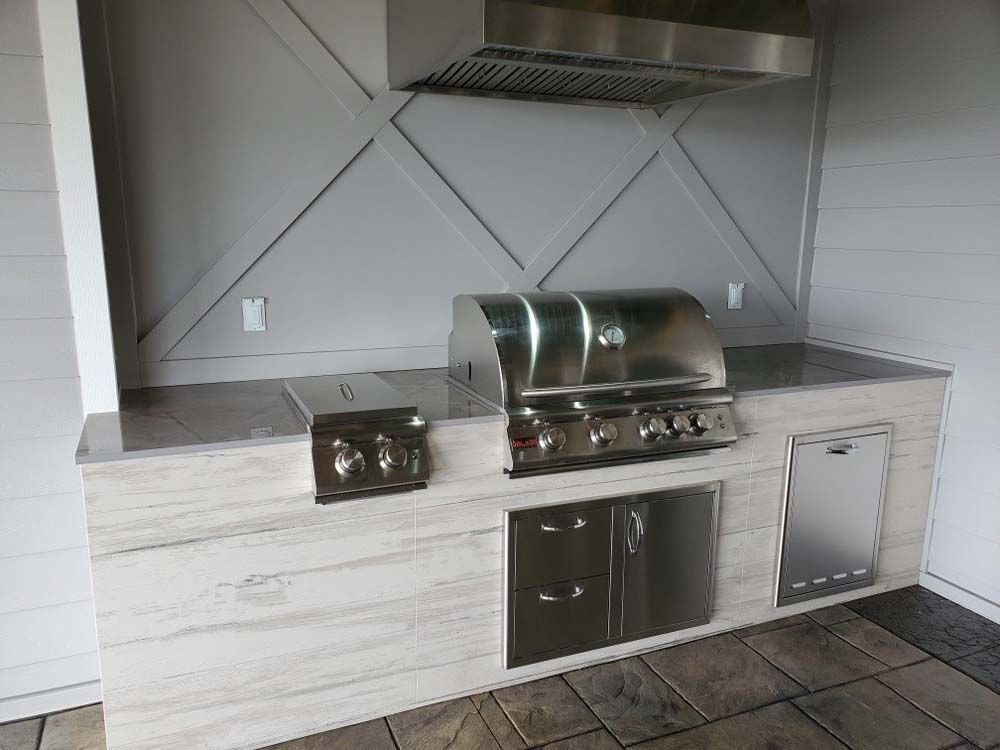 A stainless steel grill is sitting on top of a counter in a kitchen.