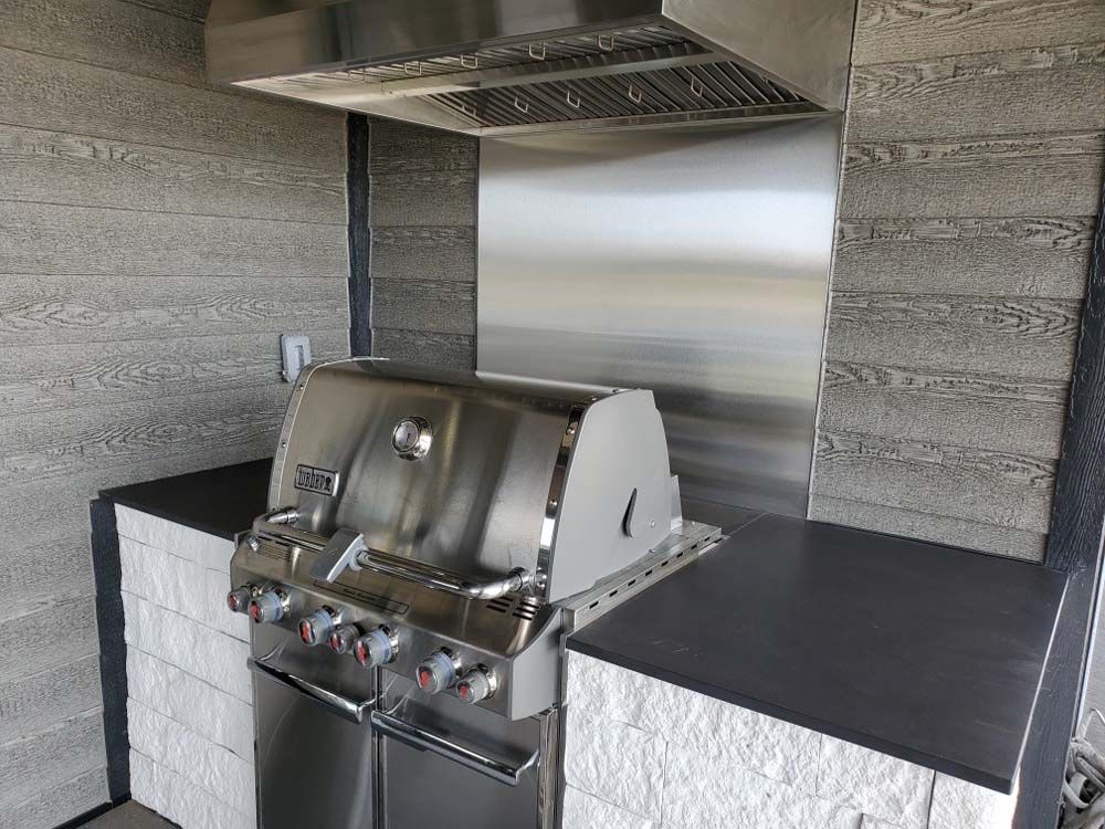 A stainless steel grill is sitting on a counter in a kitchen.