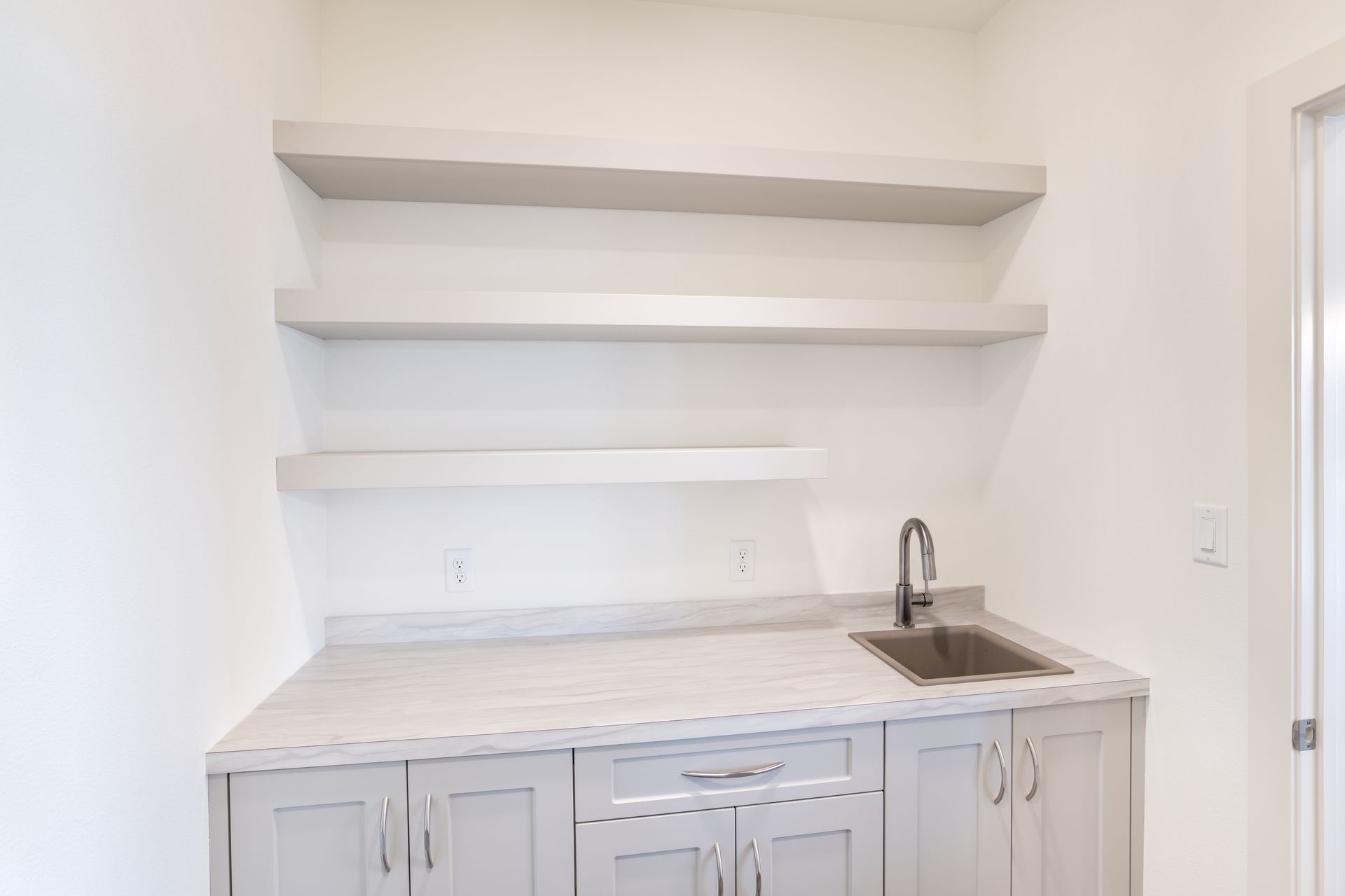 There is a sink and shelves in the kitchen.