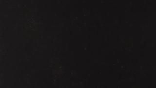 A close up of a black background with a few white dots on it.