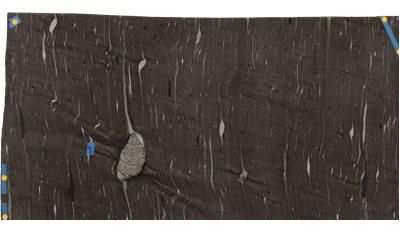 A close up of a piece of black fabric with a hole in it.