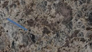 A close up of a granite counter top with a blue arrow pointing to it.