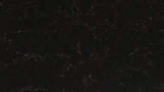 A close up of a black surface with a marble texture.