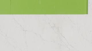 A green envelope is sitting on top of a white marble counter.