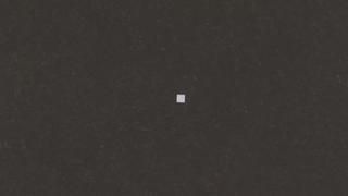 A small white square is floating in the air on a black background.