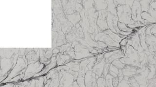 A close up of a white marble counter top with a white square in the middle.