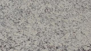 A close up of a white granite counter top.