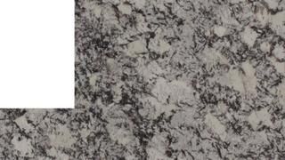 A close up of a granite counter top with a white border.