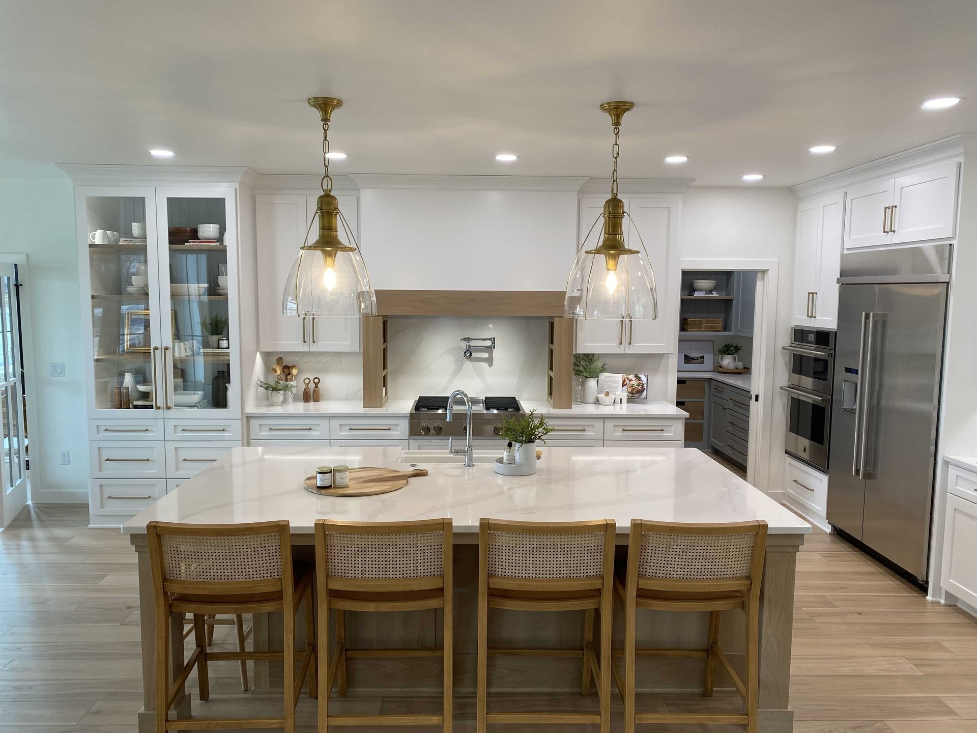 A kitchen with white cabinets and stainless steel appliances and a large island.