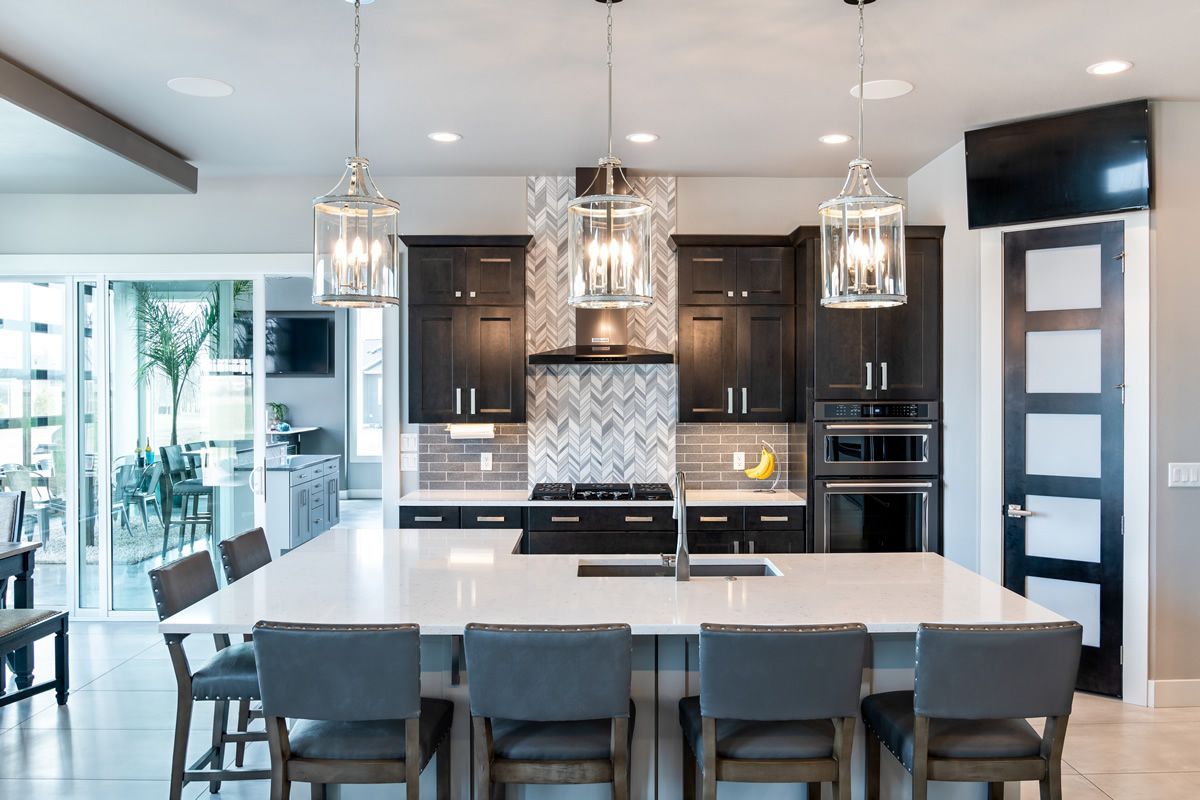 A kitchen with a large island and a dining table and chairs.