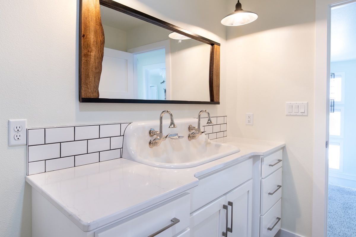 A bathroom with a sink , mirror and cabinets.