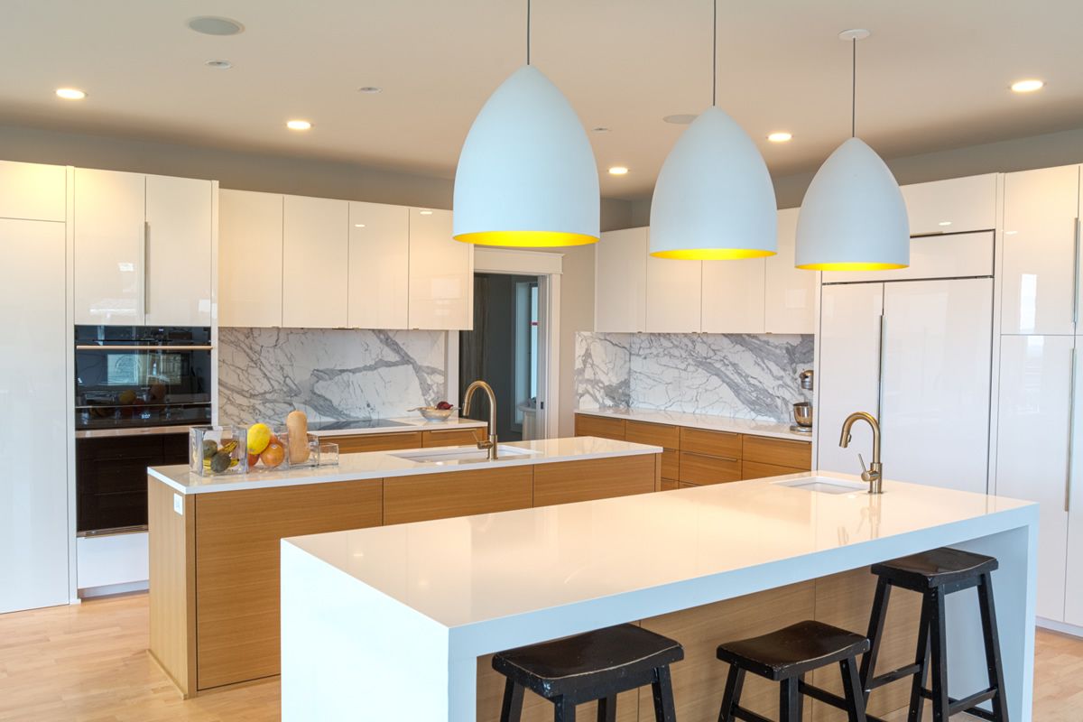 A kitchen with white cabinets and a large island