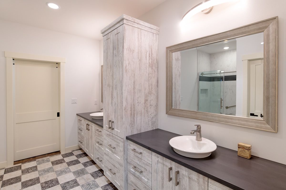 A bathroom with two sinks and a large mirror.