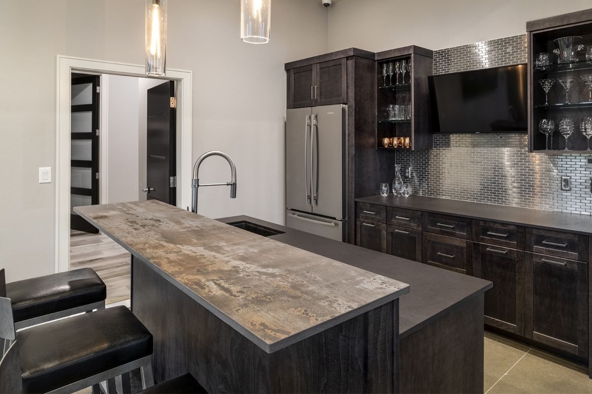 A kitchen with a large island and a refrigerator.