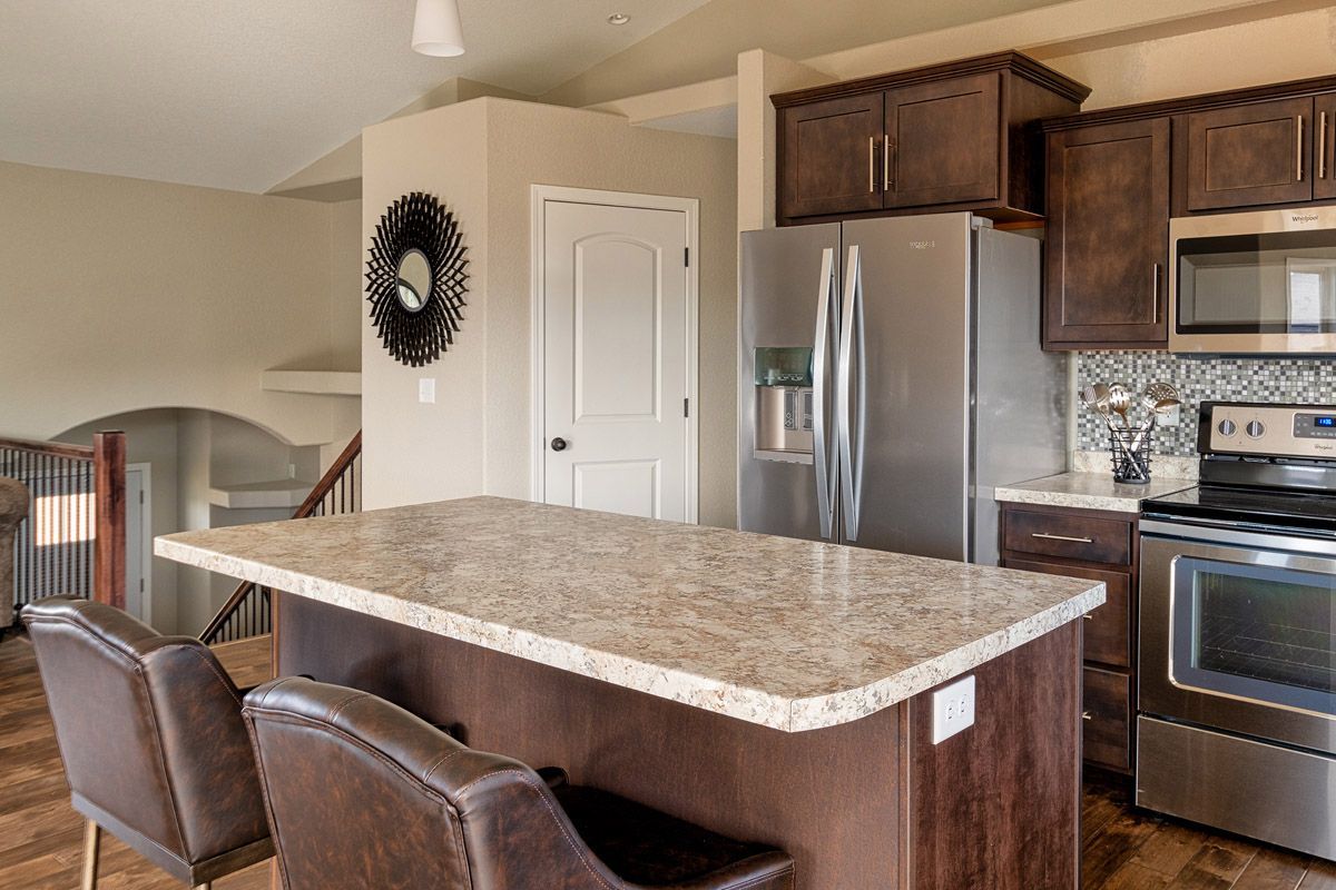A kitchen with stainless steel appliances , granite counter tops , and a large island.