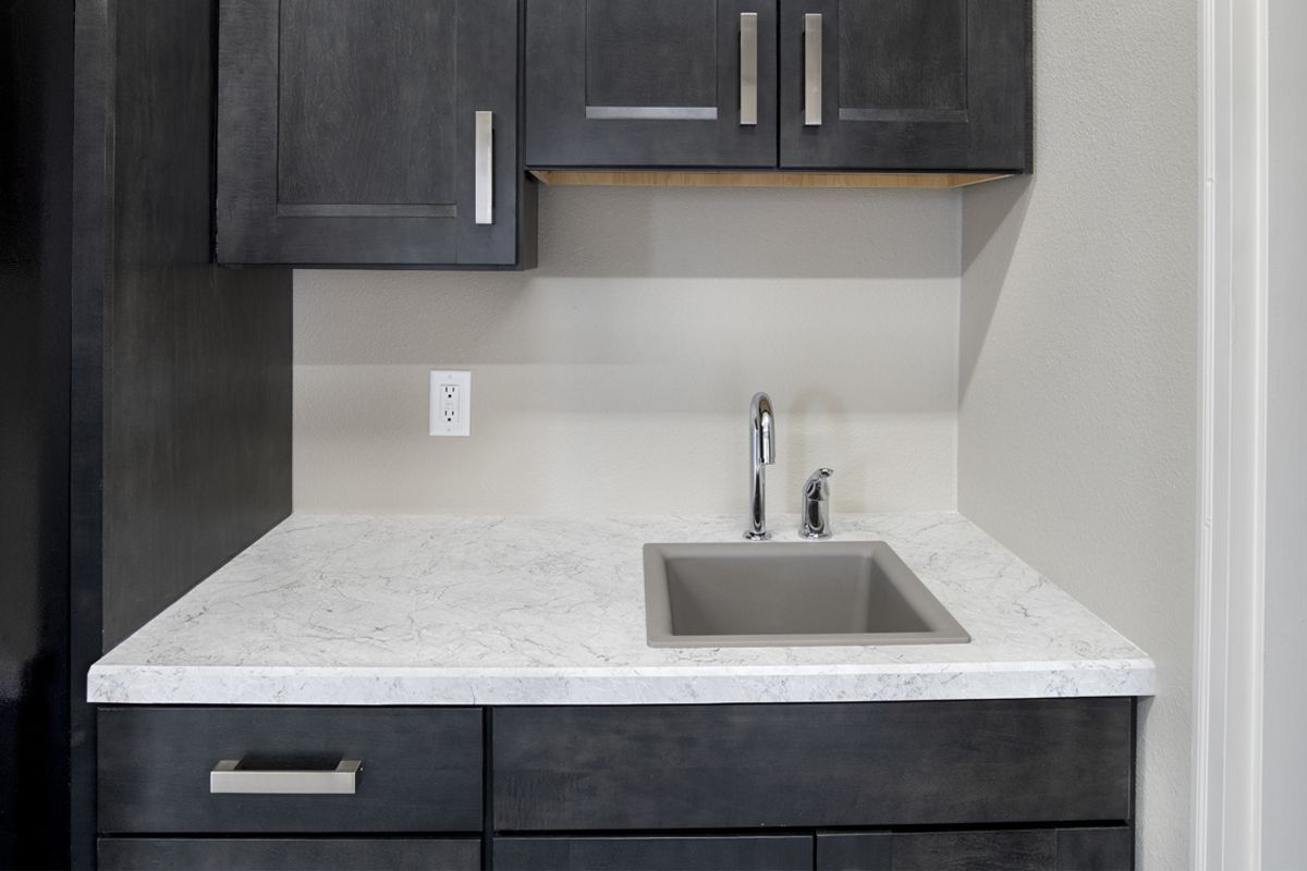 A kitchen with black cabinets and a sink.