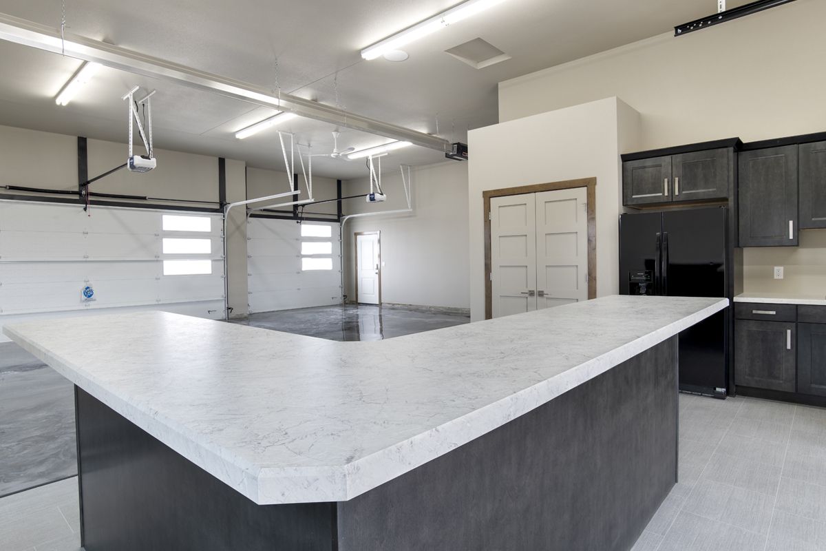 A kitchen in a garage with a large island in the middle