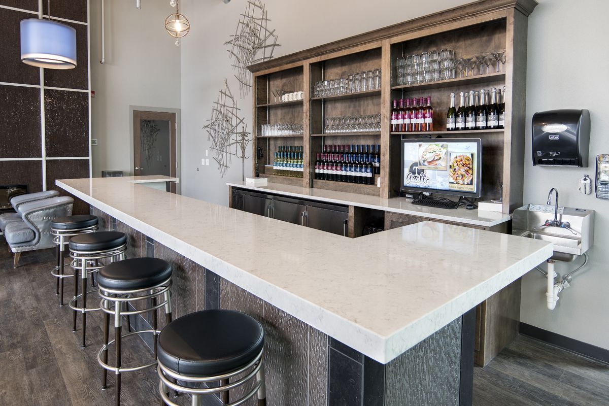 A bar with a long counter and stools in a restaurant.