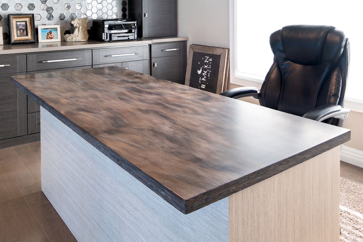 A large wooden desk with a black chair in a home office.
