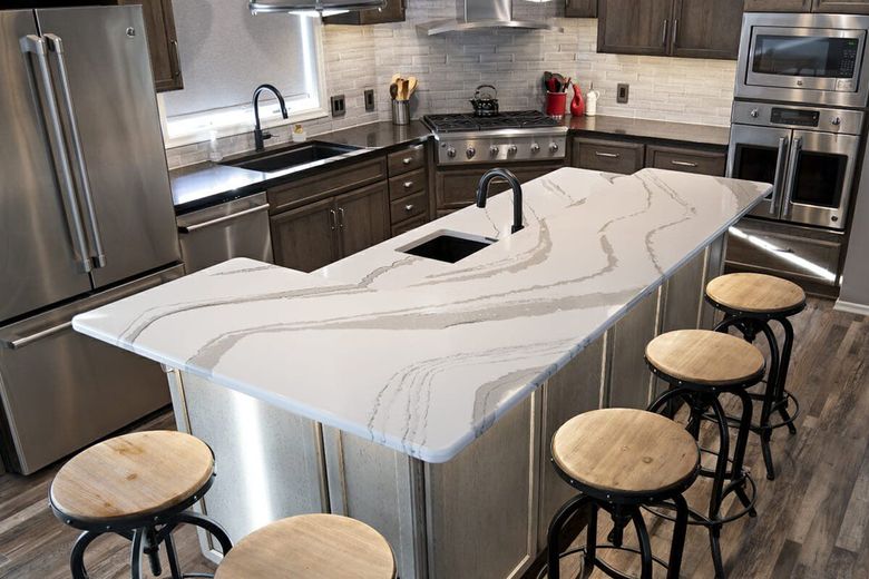 A kitchen with a large island and stools.