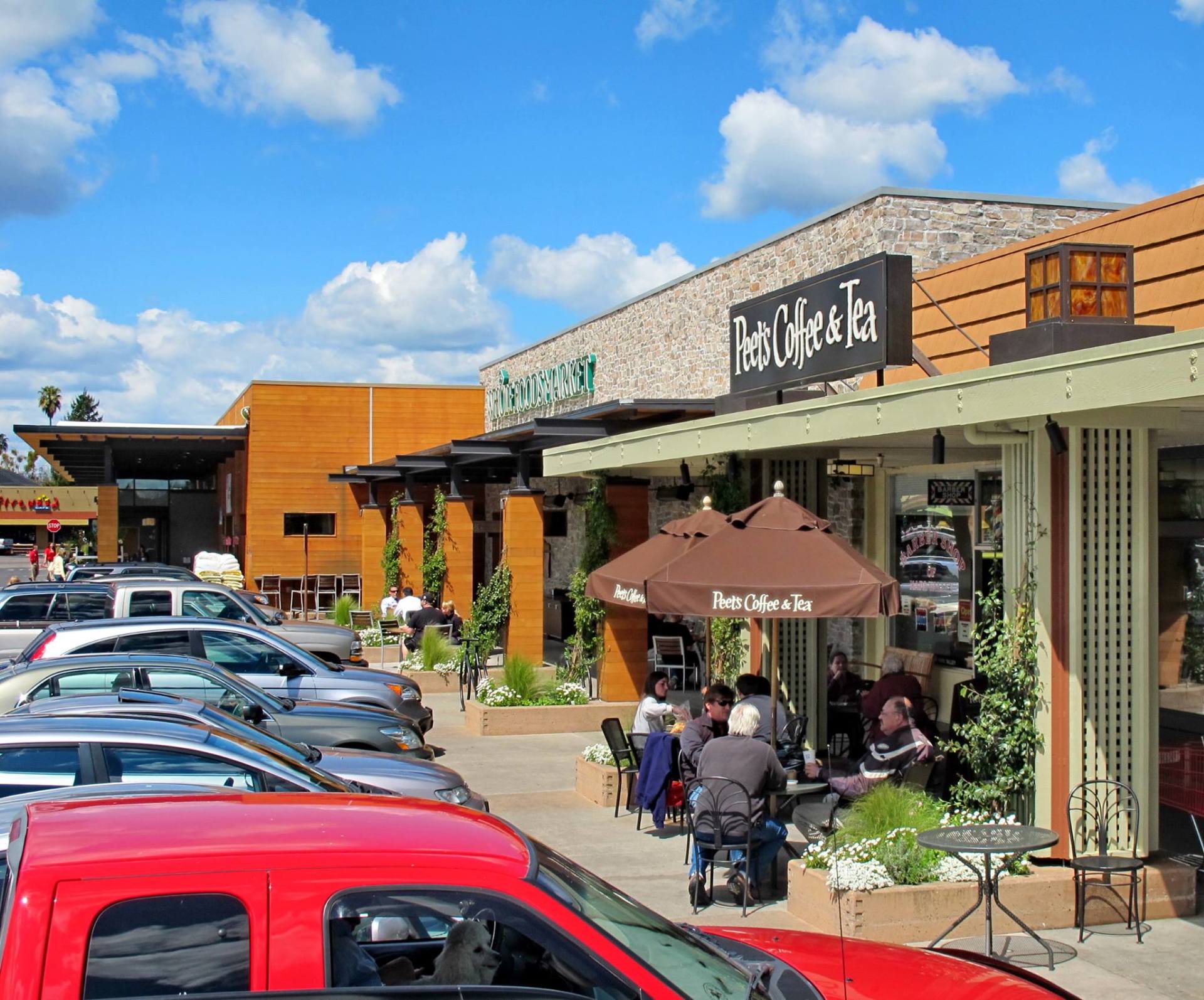 A red truck is parked in front of a coffee shop