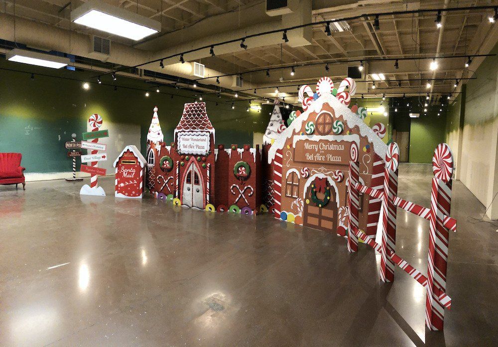 A large empty room decorated for christmas with gingerbread houses and candy canes.