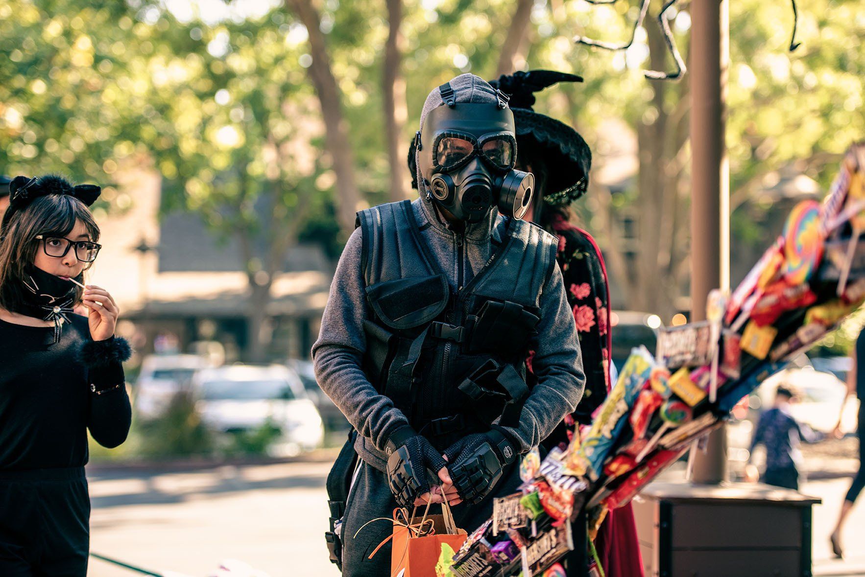 A man in a gas mask is holding a trick or treat bag.