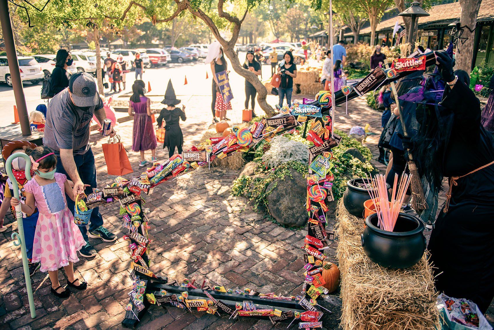 A group of people are standing around a table filled with candy.