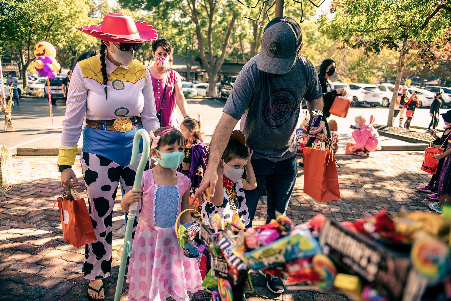 A group of people in costumes are walking down a street.
