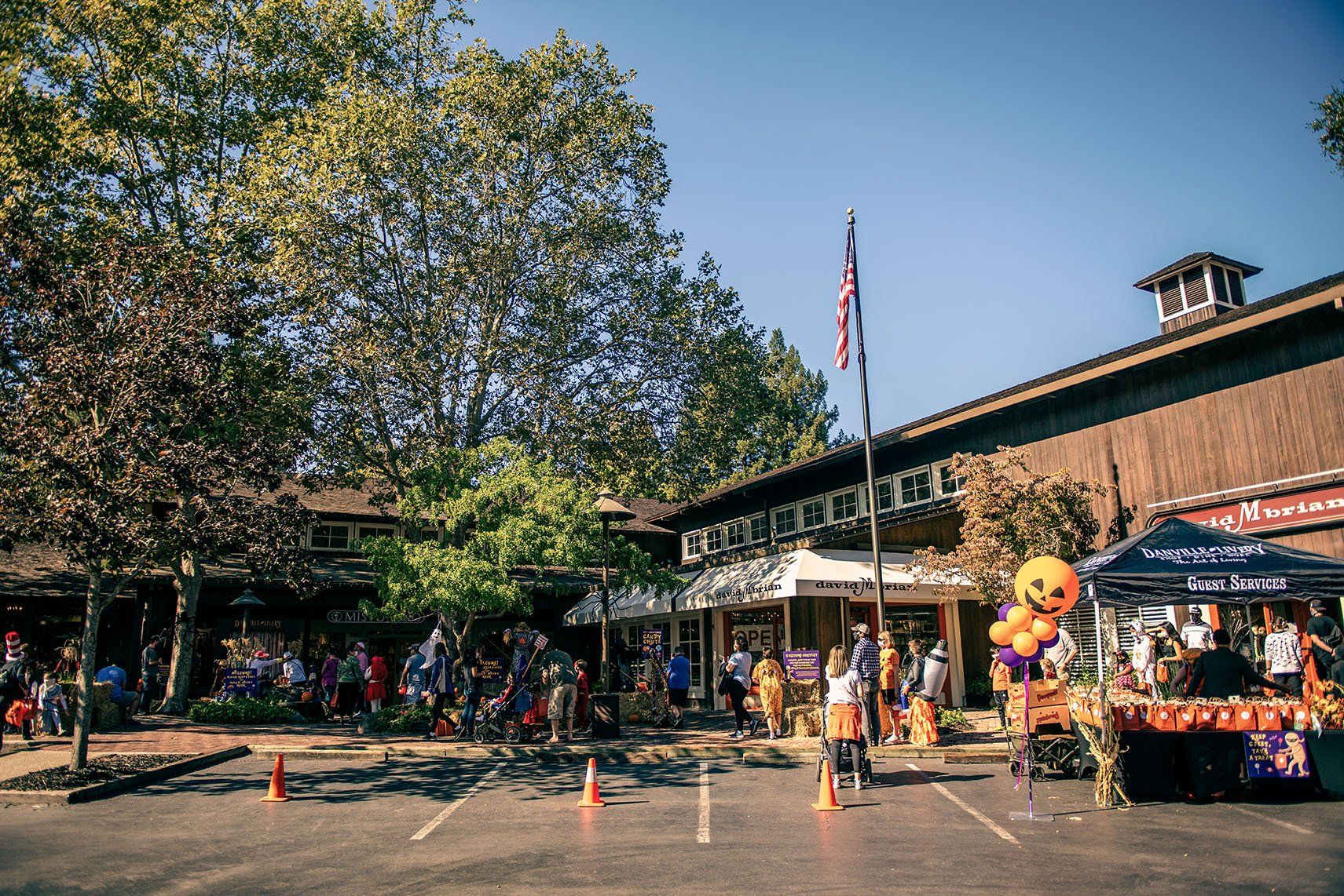 A group of people are standing in a parking lot in front of a building.