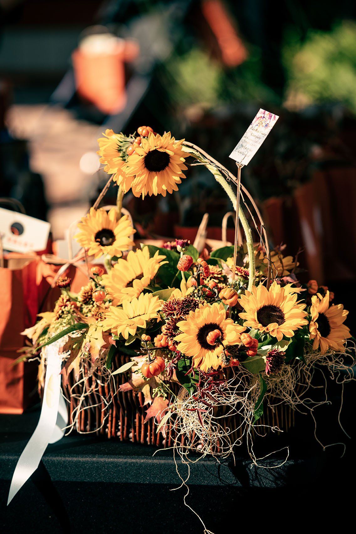 A basket filled with sunflowers is on a table.