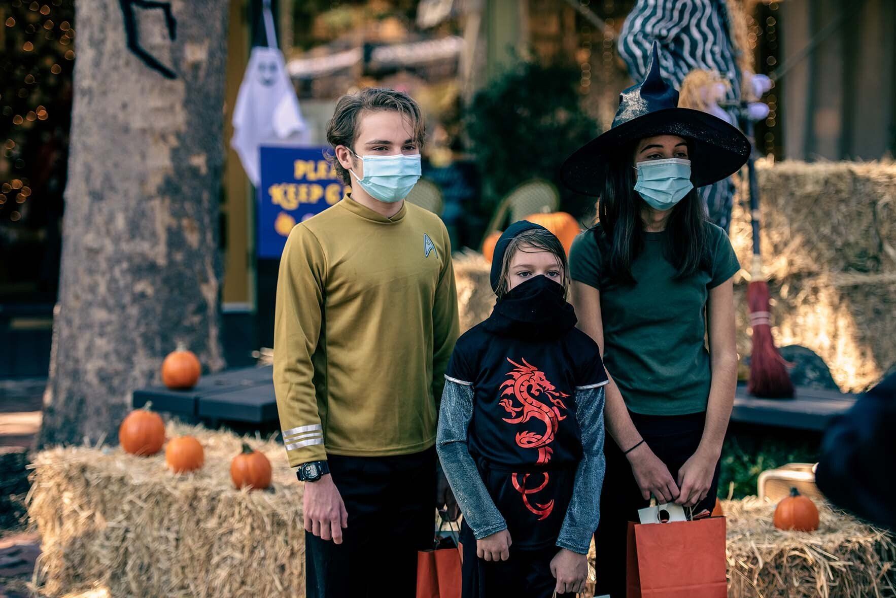 A group of people wearing face masks are standing next to each other.