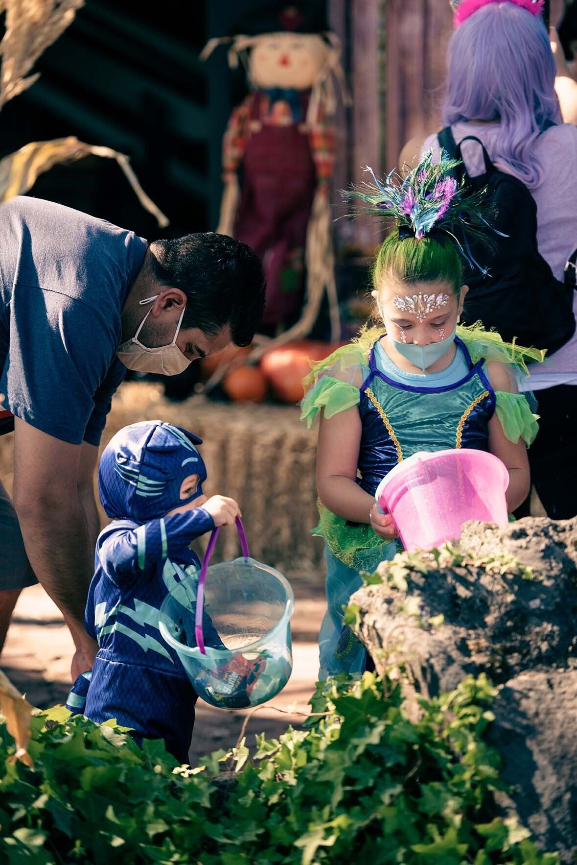 A man is standing next to a little girl in a halloween costume.